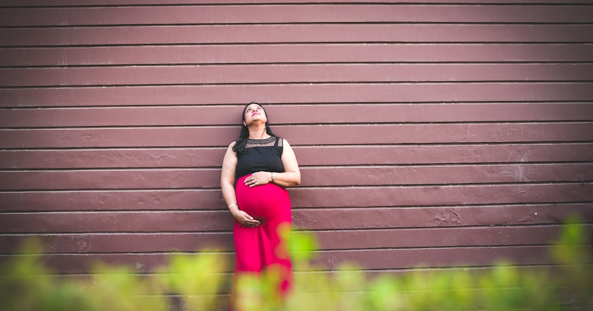 Gravid kvinna poserar i klänning