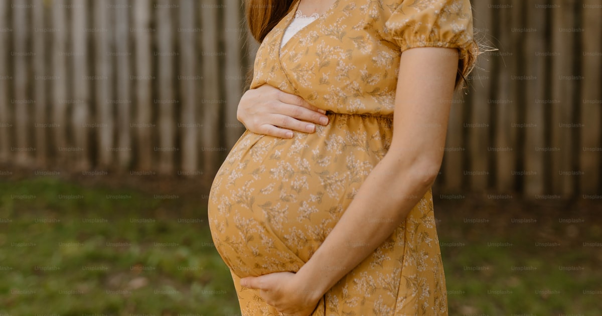 Gravid kvinna i gul klänning