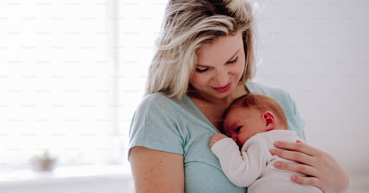Ung mamma håller nyfött barn hemma