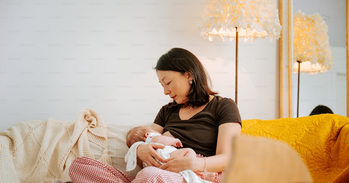 Mamma ammar bebis i soffan hemma