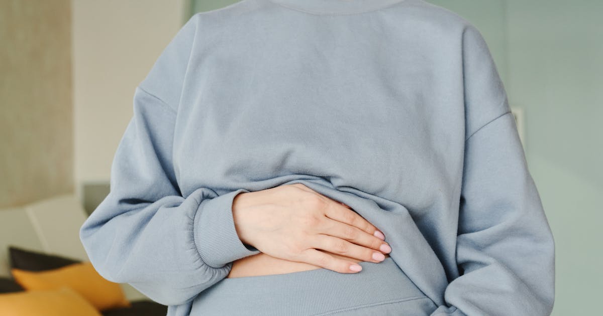 Gravid kvinna som håller sin mage tidigt i graviditeten