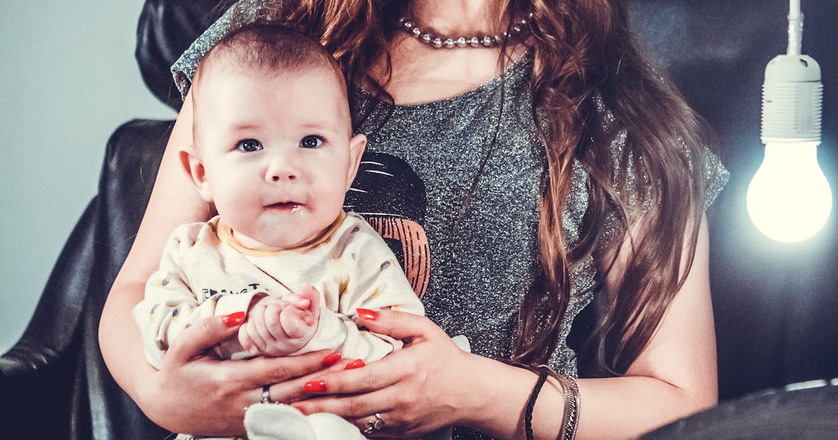 Mamma med bebis nära bröstet – amma i bärsjal