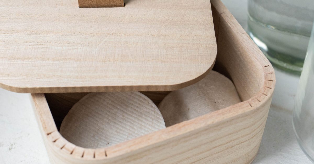 Vita runda inlägg förvaras i en liten trälåda