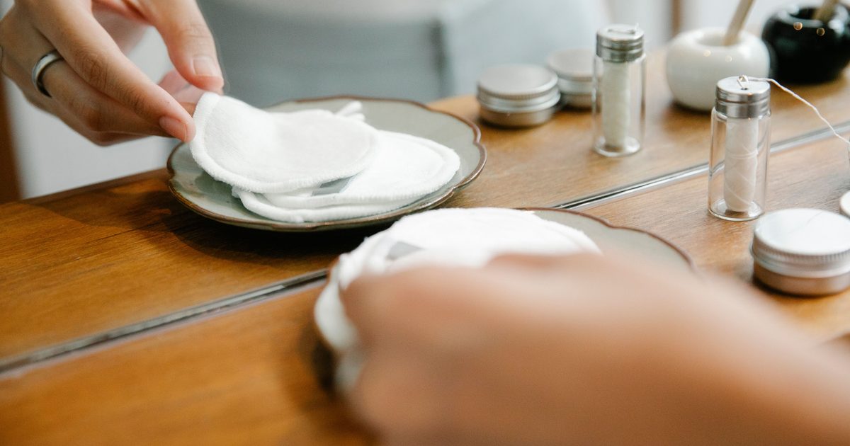 Händer plockar tvättbara inlägg i tyg från ett fat